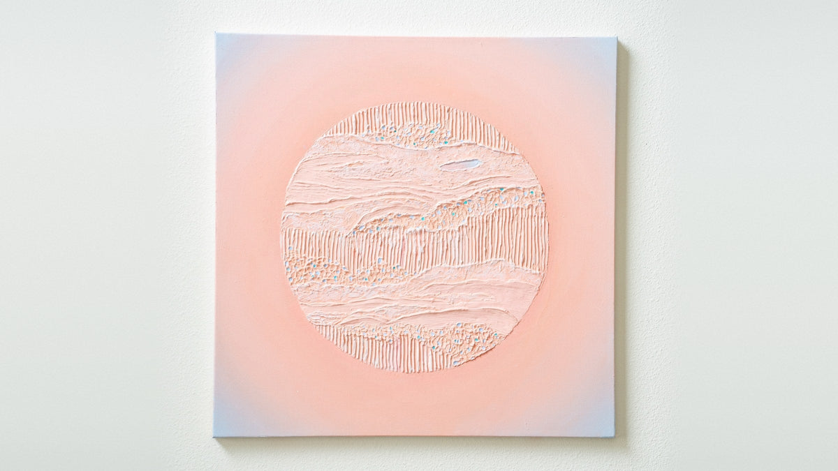 Nuqta, a 24 by 24 inch textured abstract painting in plaster and acrylic, a raised peach circle on a soft peach and blue ground