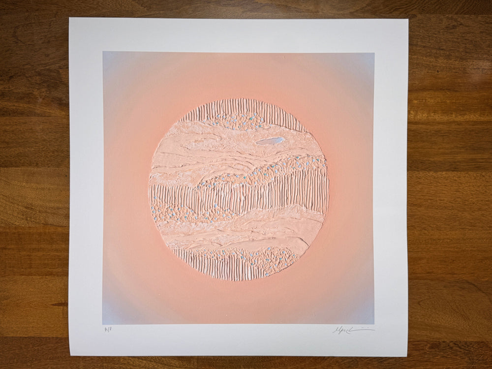 Nuqta print resting on a wood table, showing the full sheet with its white border 