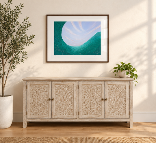 Noon framed and hung above a light wood sideboard with an olive tree, showing the scale of the print in a room
